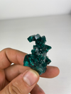 dioptase stone against a finger